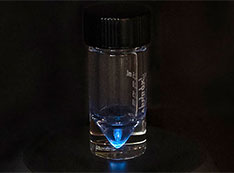 A long exposure image of actinium-225 in a bottle